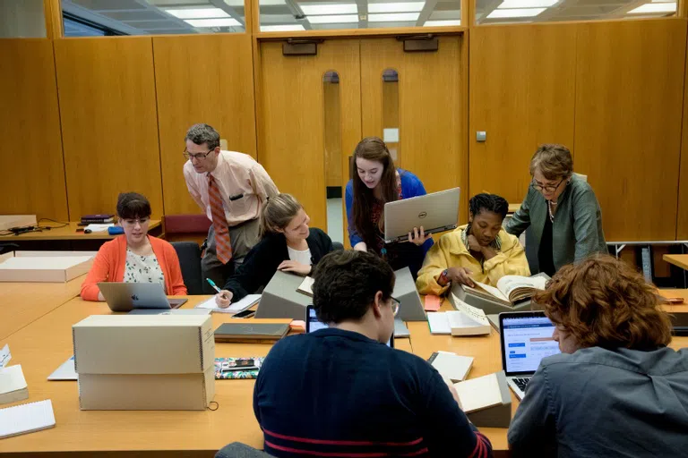 Students gathered in a room conducting research at Mudd Library