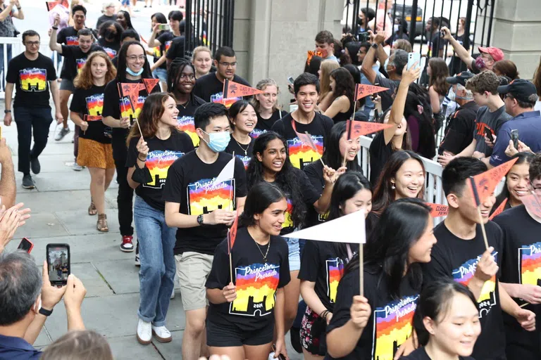 A parade of students walking through the gates.