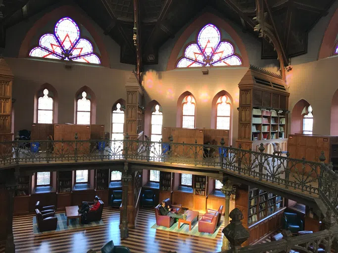 Inside of building with stain glass and a tall foyer.