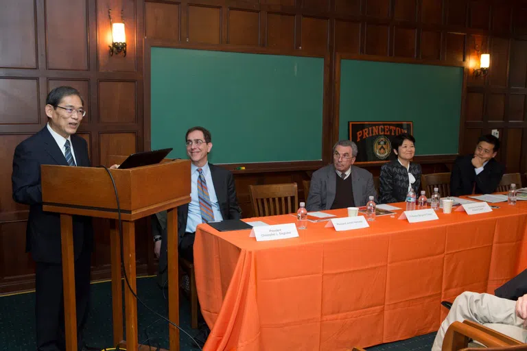 University members sitting behind an orange table for a panel event.