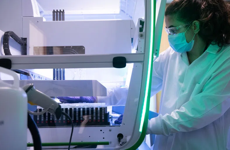 A masked student working in the lab. 