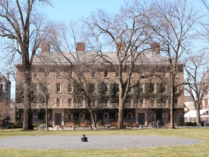 Ivy-clad brick building with a green quad in front