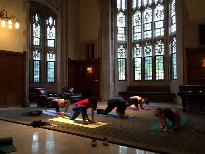 A common room with students doing yoga