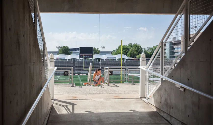 A student stretching on the stadium stairs