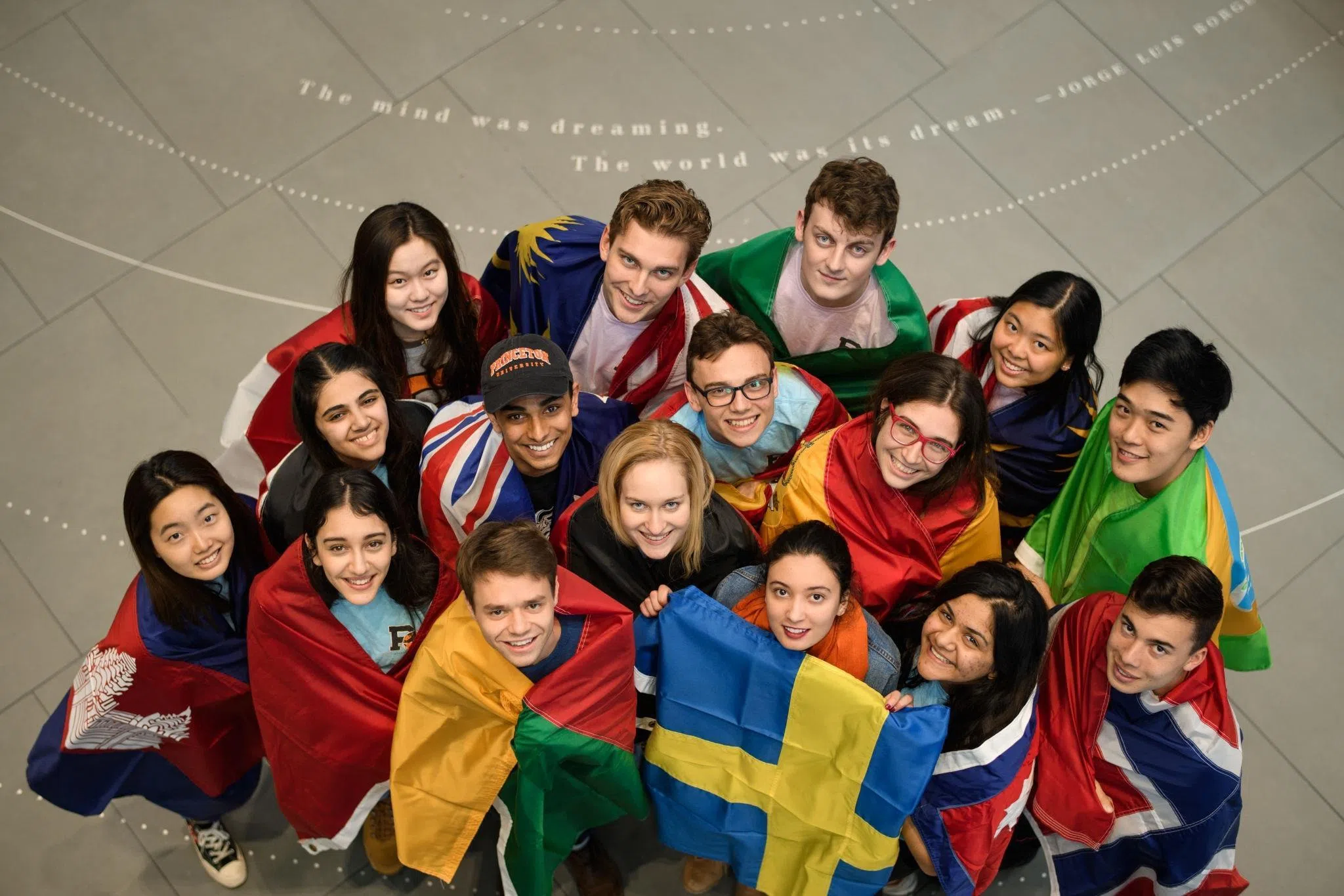 Students wearing different flags gathered together.