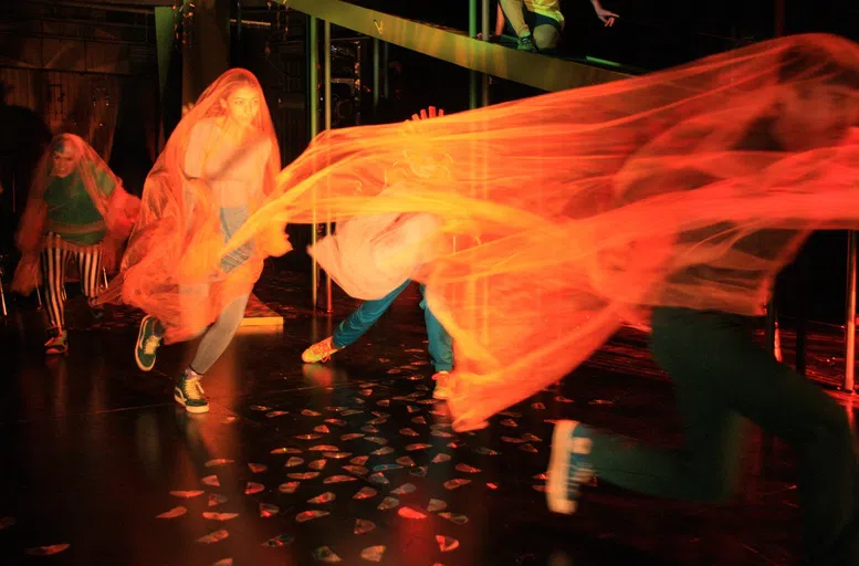 Students wrapped in orange sheer material for art installation.