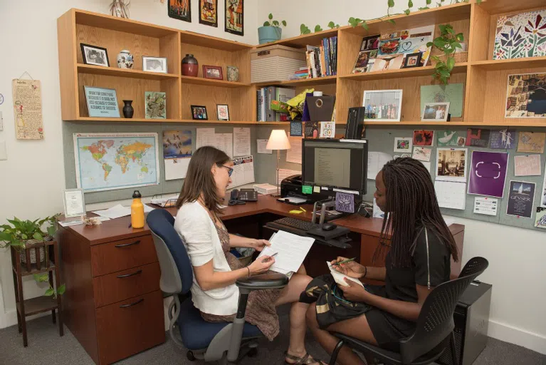 Loeb Center staff member sits with student in office 