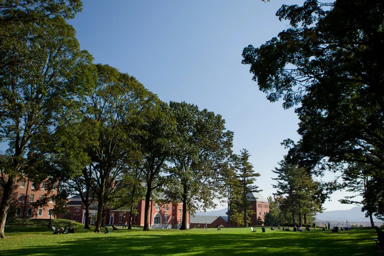 Large outdoor green space with mountains in the background in fall