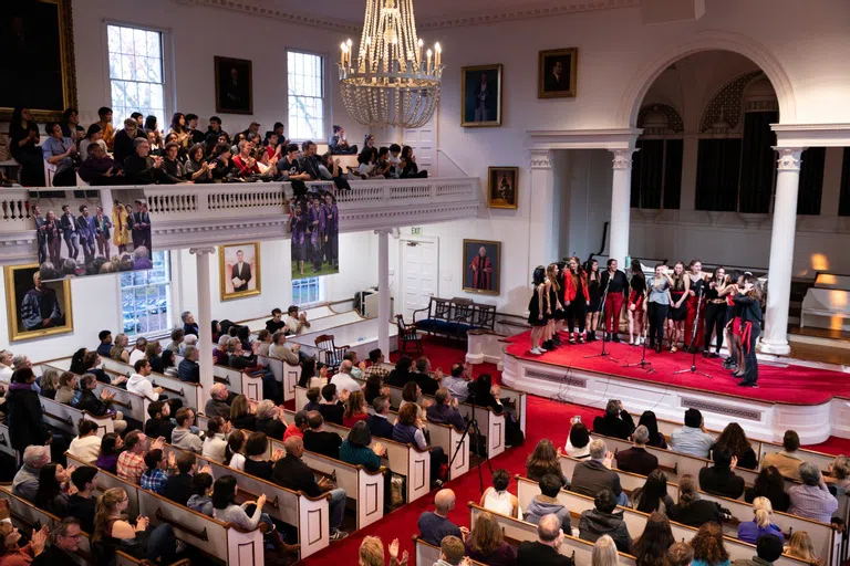 Interior shot of Johnson Chapel with pews filled with family members watching an acapella group perform on stage.