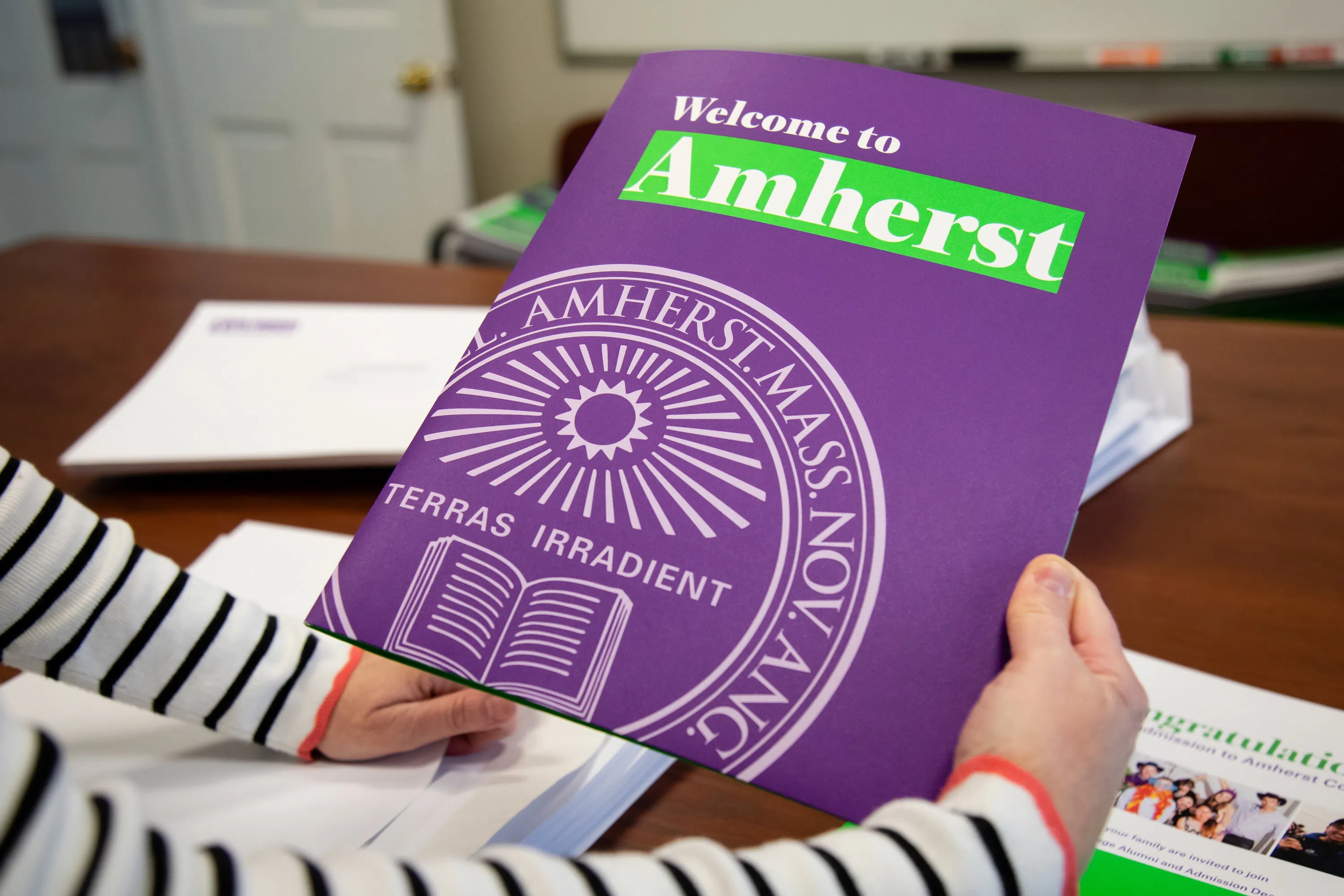 Bright purple folder with Amherst seal on it.