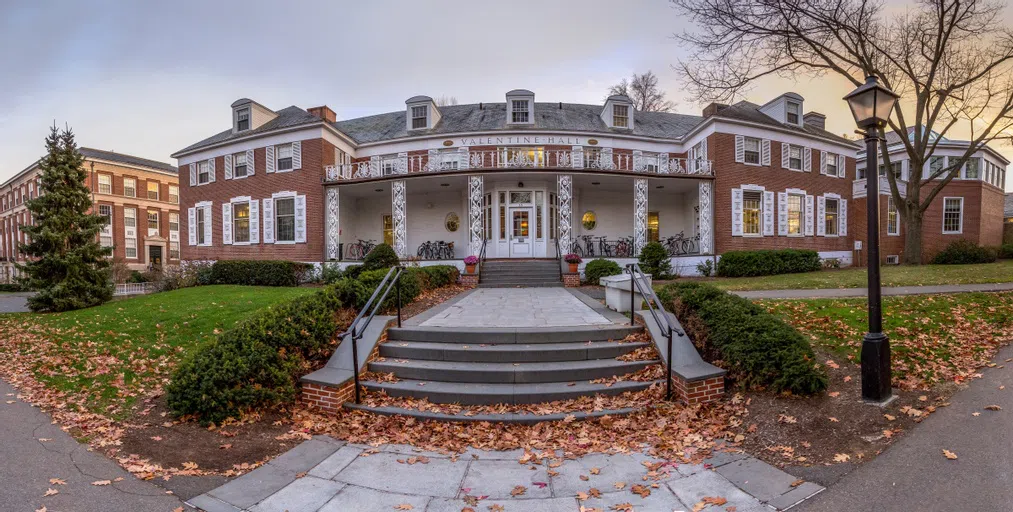 Exterior shot of Valentine Dining Hall with leaves around main stairwell.