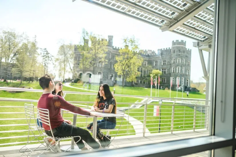 Students sitting on the Commons balcony with the Castle in the background
