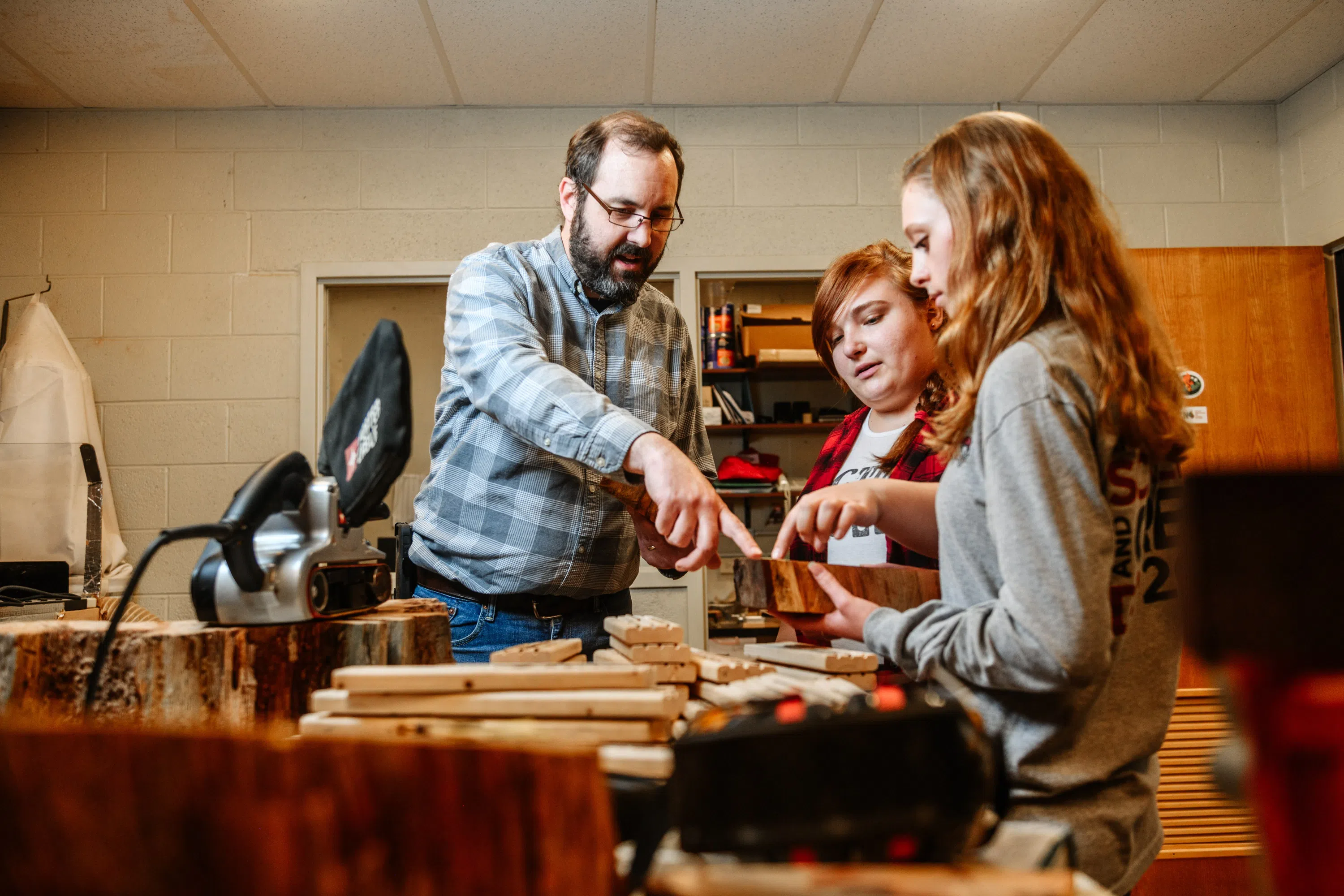 Students in a dendrochronology lab examining tree stumps with their professor
