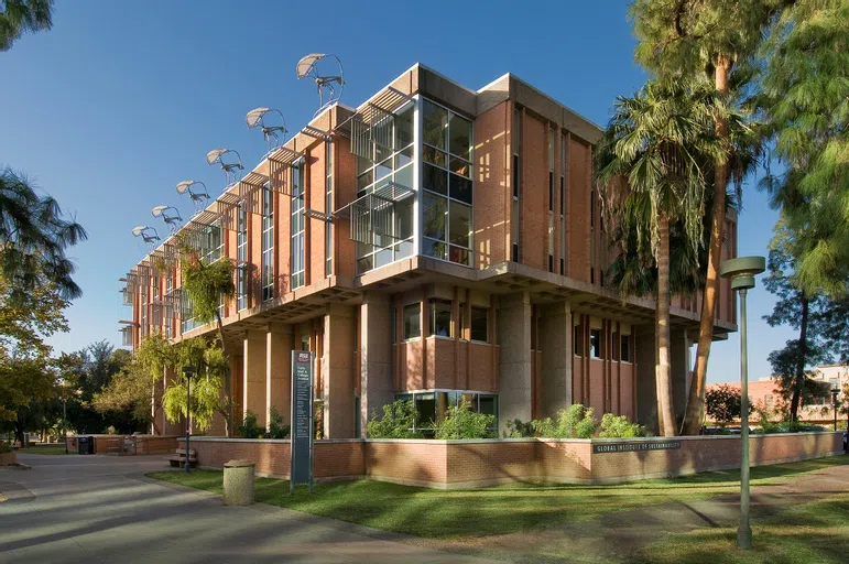 Exterior of Wrigley Hall. Roof has windmills attached to it. 