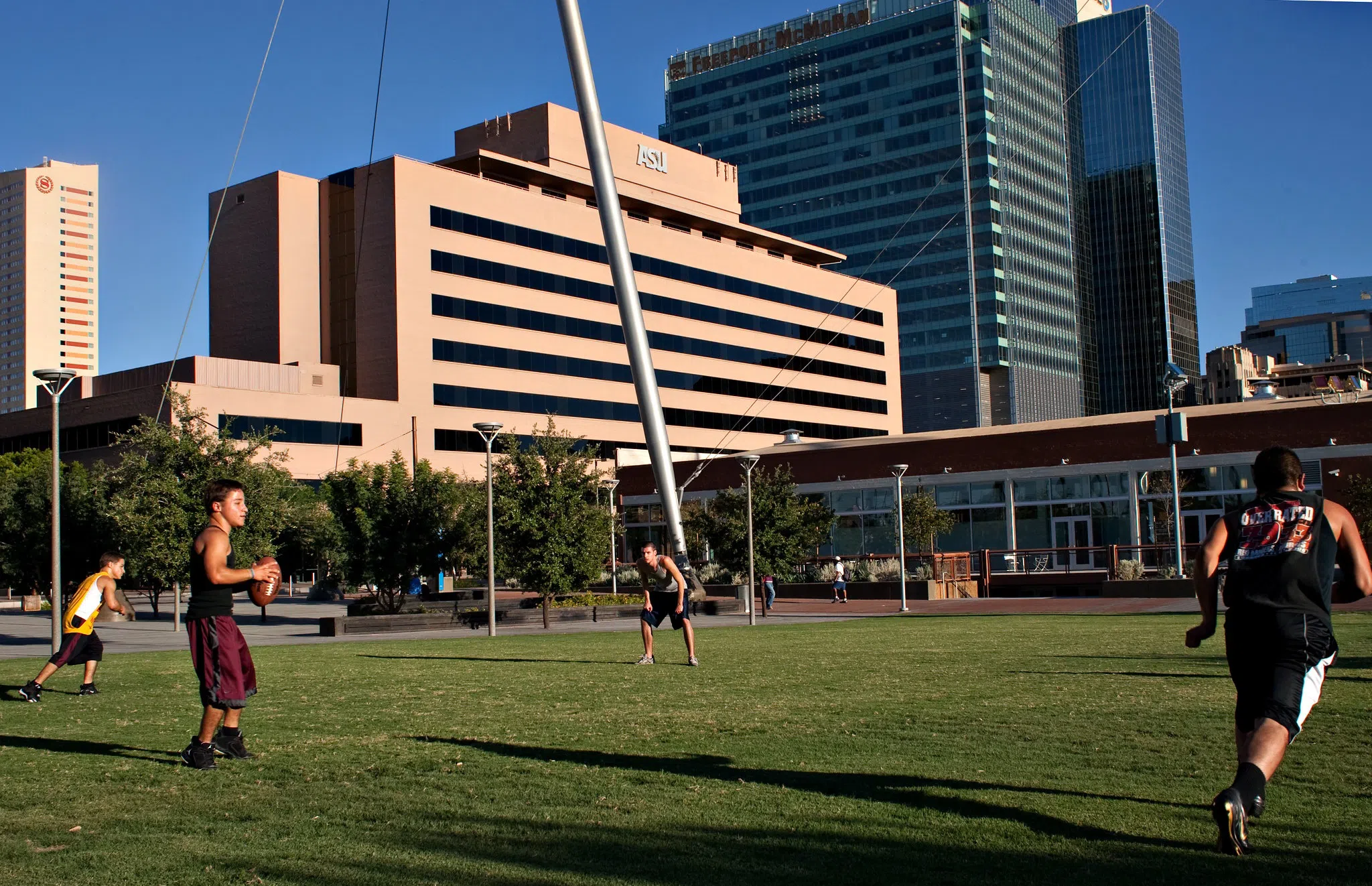 Students playing football at Civic Space Park with University Center Building in the background. 