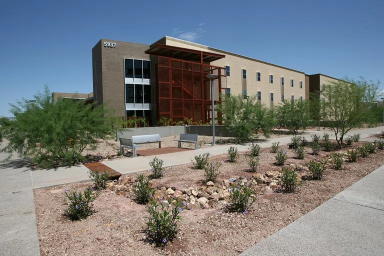 Exterior of Century Hall with desert landscaping.