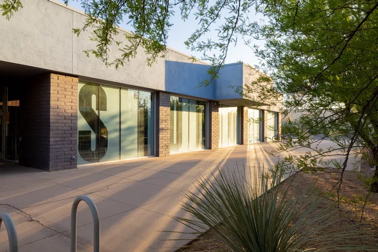 Sun streaks reflect off of glass windows that spell out "Studio 90" on the Engineering Design Studio building.