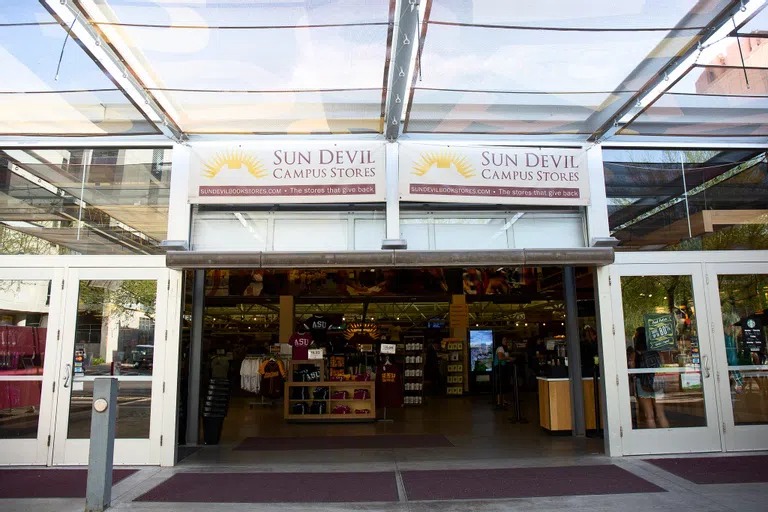 Open garage door entrance to store with Sun Devil Campus Store signage above open door. 