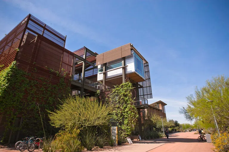 Gravel walkway and desert landscaping in front of three-story metal building.