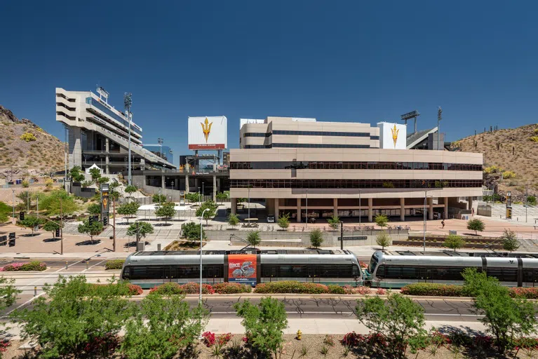 Veterans Way street and a light rail train in front of Mountain America Stadium.