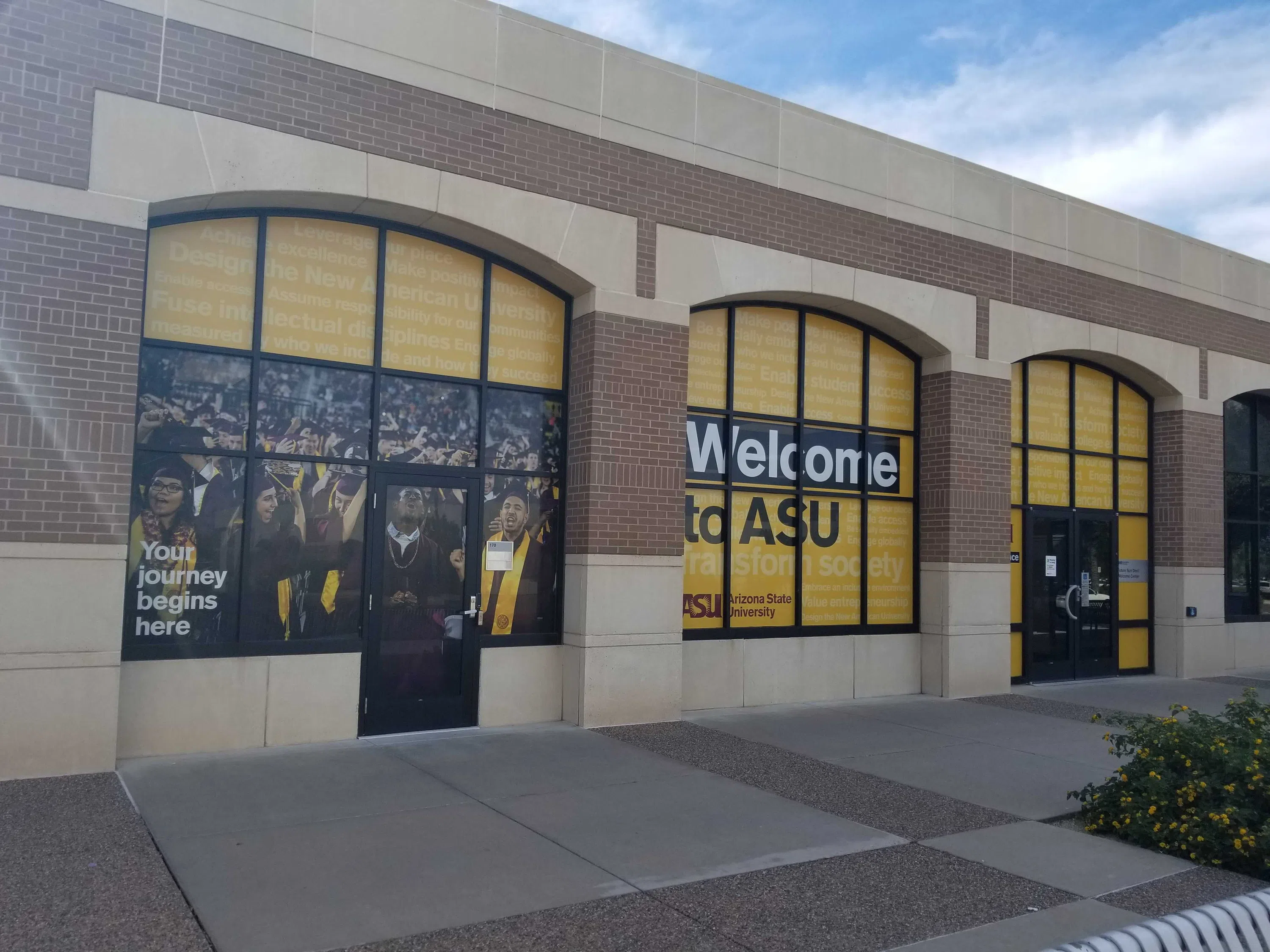 One story brick building with gold-wrapped windows that say Welcome to ASU.