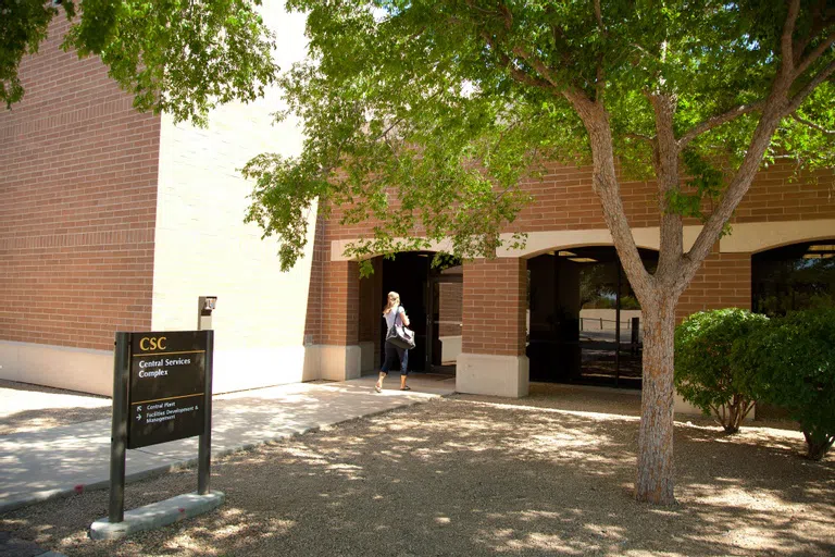 Woman walking into entrance of Central Services Complex.