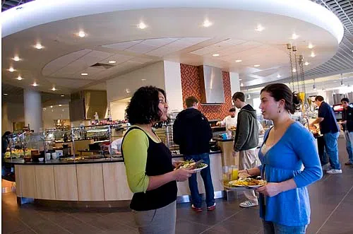 Two diners stop to chat next to the salad bar