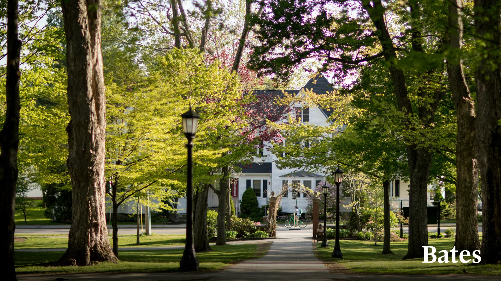 A student bikes past Lindholm House, home of the Office of Admission