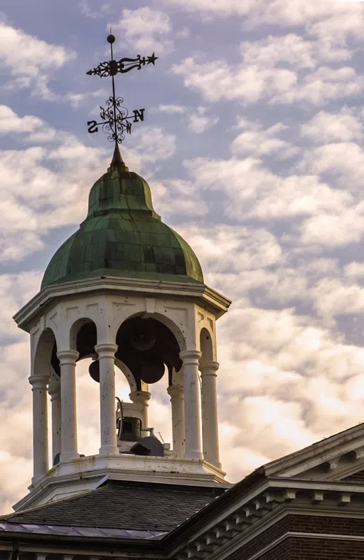 A close view of the Hathorn Hall Bell Tower juxtaposed by the sunset