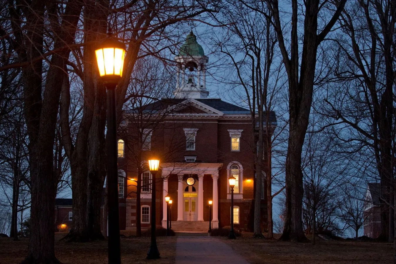 Hathorn Hall at night illuminated by Bates the lamps that light the pathways of the Quad