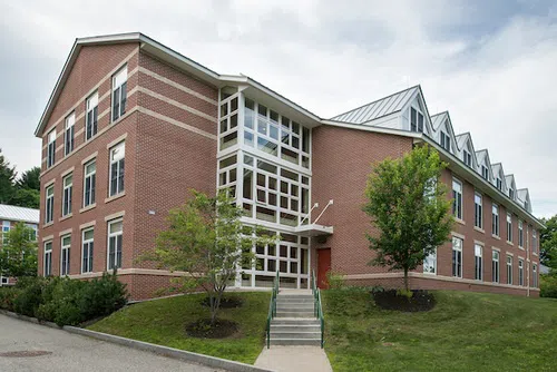 A frontal view of 280 College Street Dorm. The building is brick with glass window cutouts. 