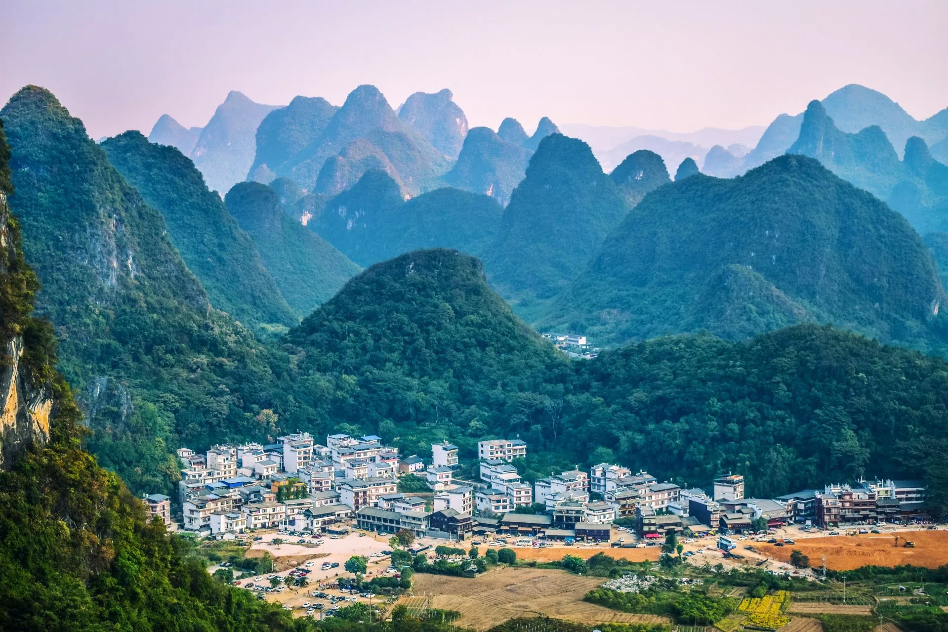 From under the arch of the Moon Hill, this photo was taken looking out at a town in the distance outside of Yangshuo, China. Behind the town are karst mountains, for which this region is well-known.