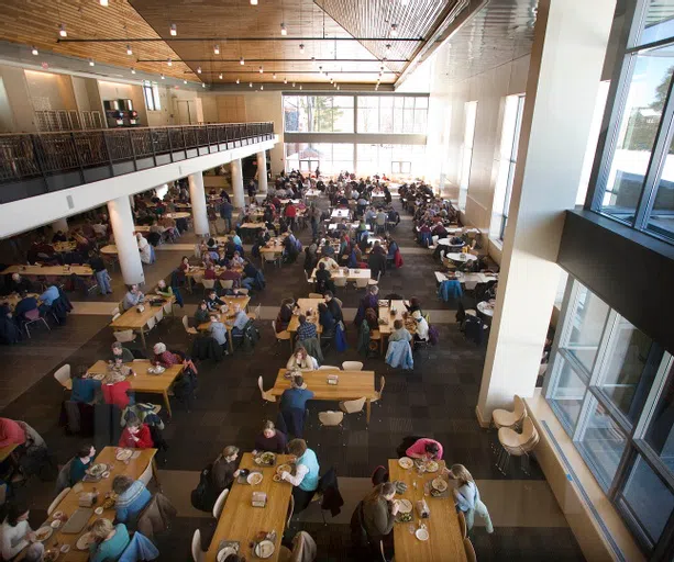 Interior of Commons Dining Hall shows many students clustered at tables