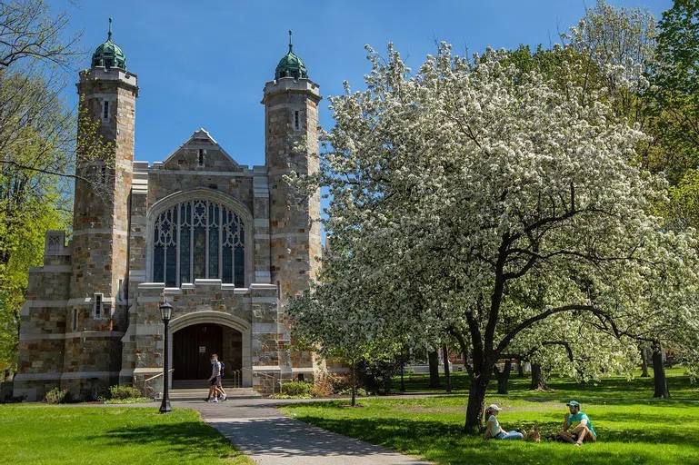 An exterior view of Gomes Chapel in the spring. The building is made of light brick and has two iconic towers.