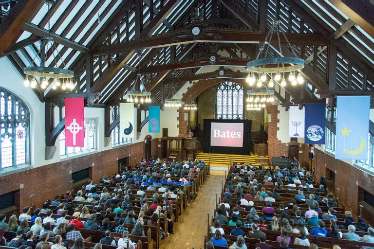 Students are gathered in the pews of Gomes Chapel.