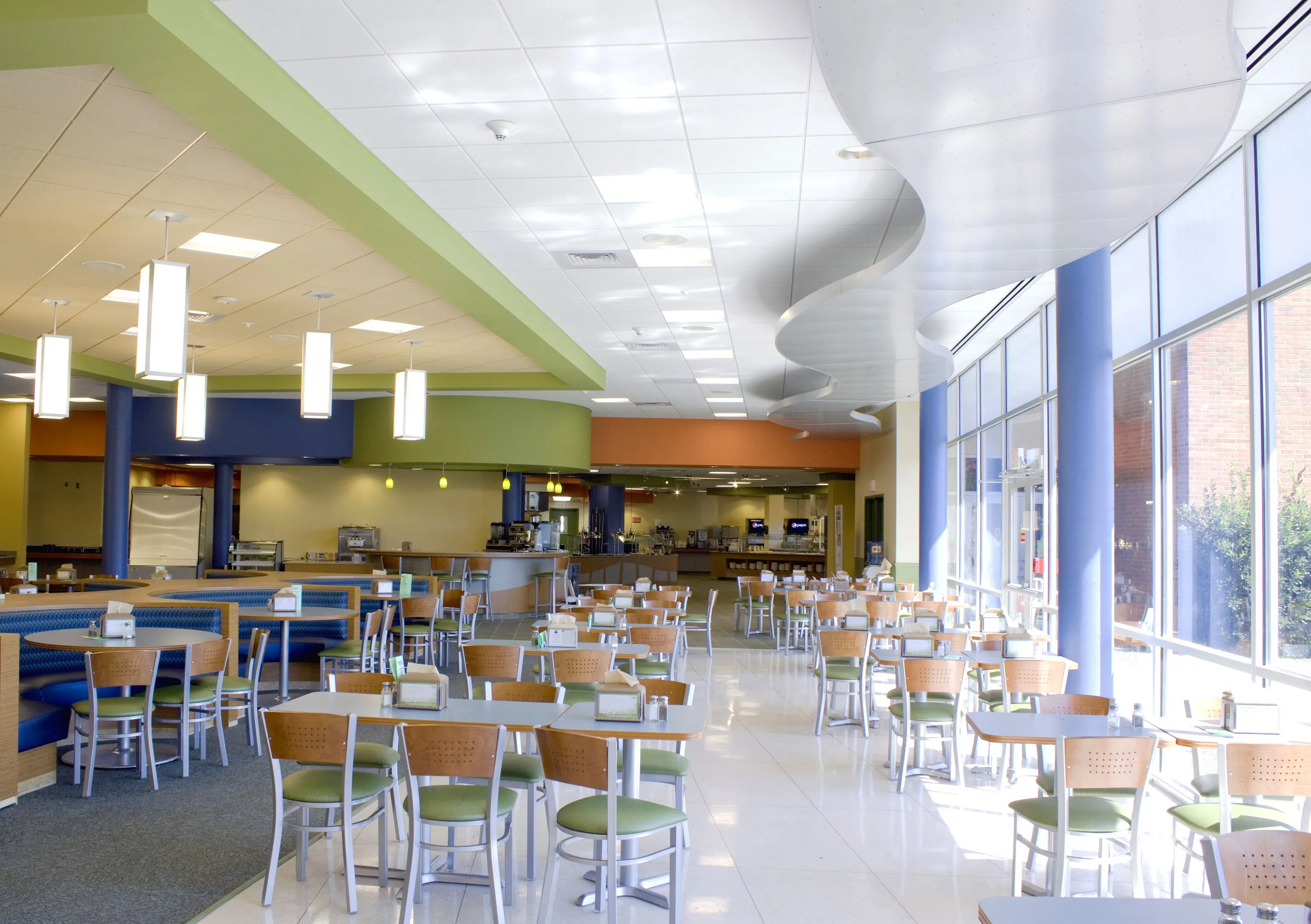 Interior view of tables and chairs in bright dining hall space.