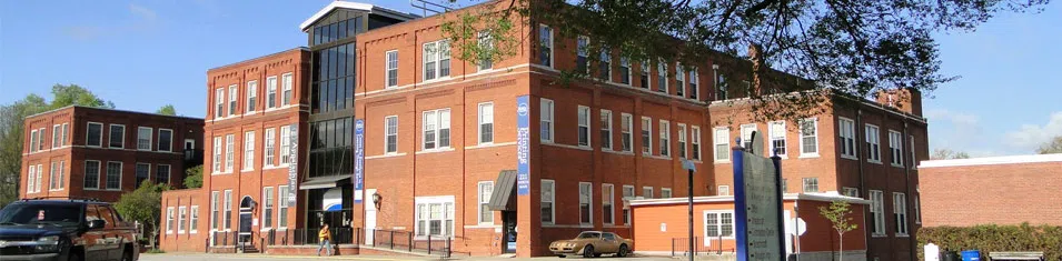 Large, three-story red brick building with banners on the front