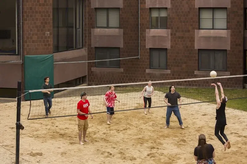 Students playing on the volleyball court in CIW