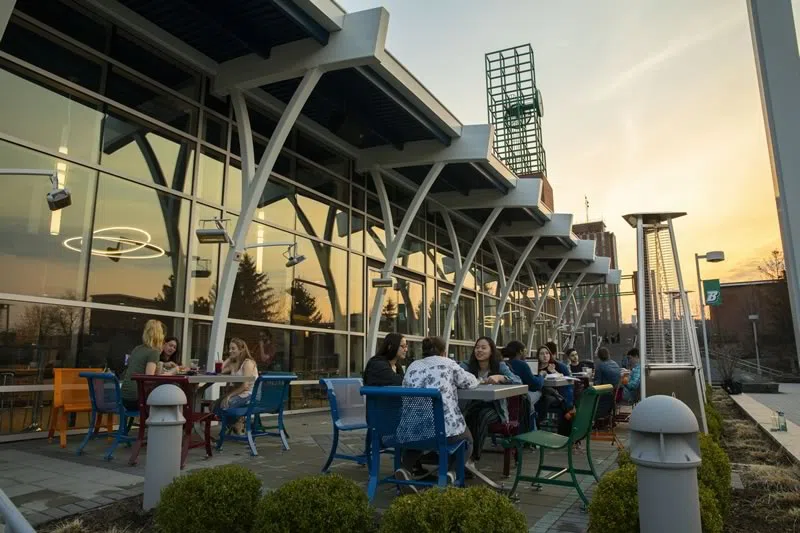Students sitting at outdoor seating area located outside the MarketPlace
