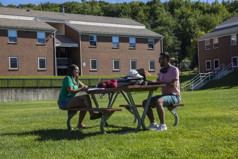 Students sitting together outside the apartment community buildings