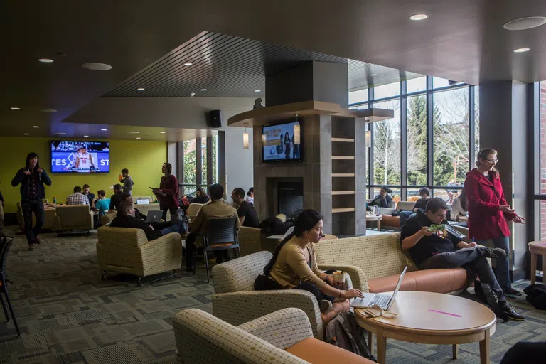 Study space within the University Union is filled with couches, tables, and tv screens.