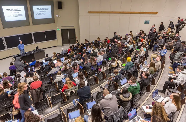 Students attending a class within a lecture hall room.