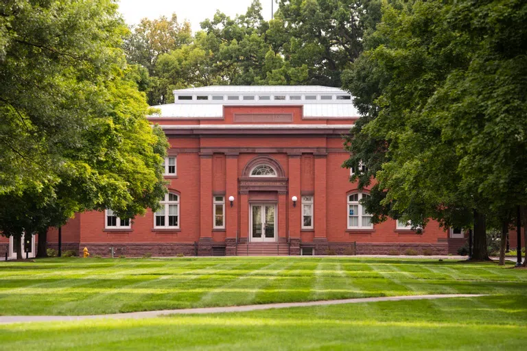 the rear exterior of Carnegie Hall, with a well-manicured lawn in the foreground