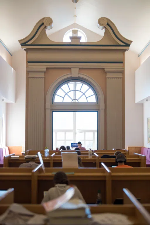 a group of students study in cubicles in front of a giant french door in Bertrand Library