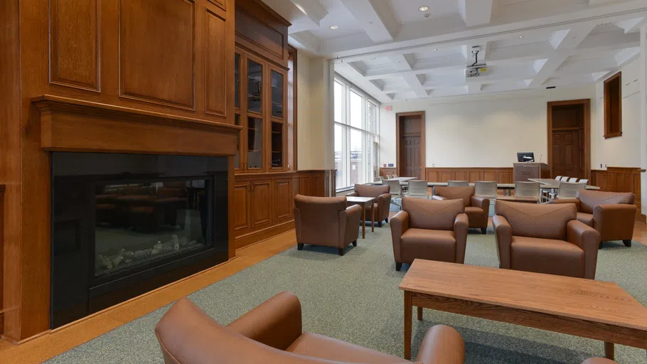 several plush chairs around a coffee table, with a fireplace to the side