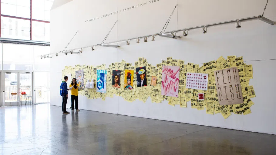 Two students stand in front of a display of posters in the Nave.