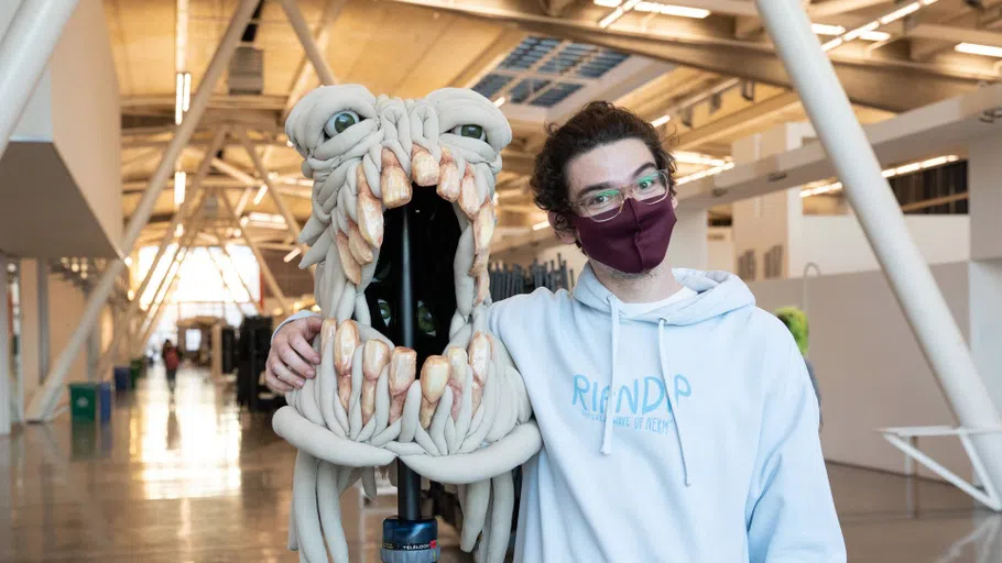 PJ Parker holds up a creature mask in the Nave.