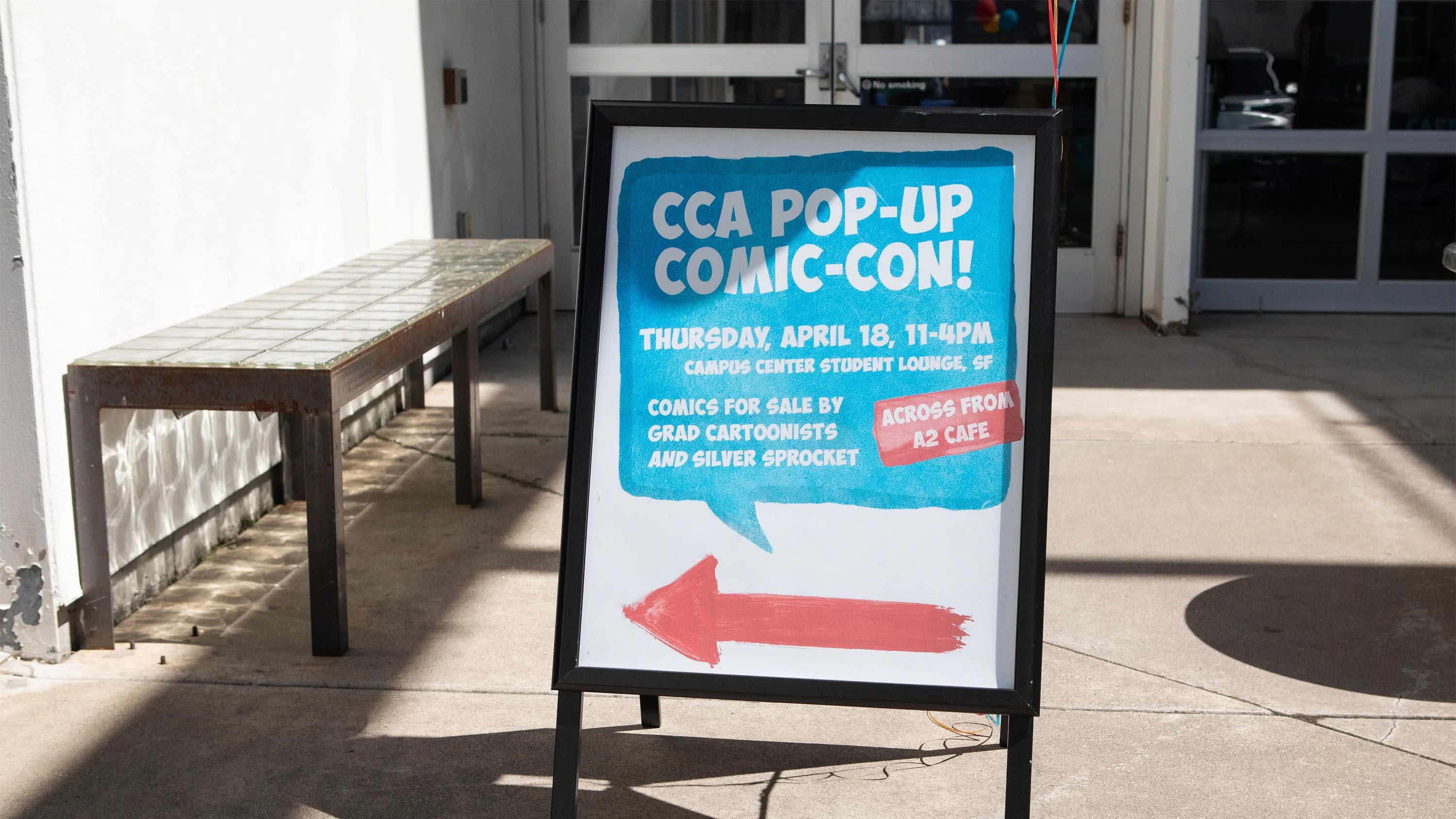 An A-frame sign, which says CCA Pop-up Comic-Con, at the entrance to our Montgomery Building.
