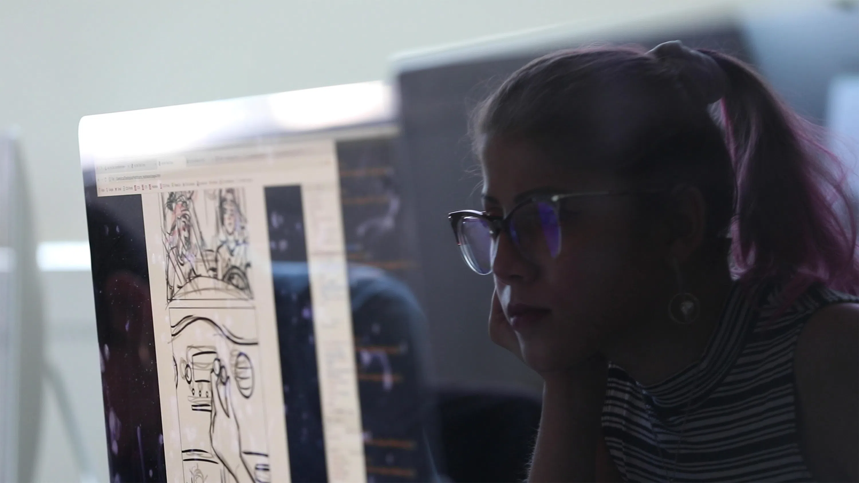 A close-up of a student working on a digital comic on an iMac.