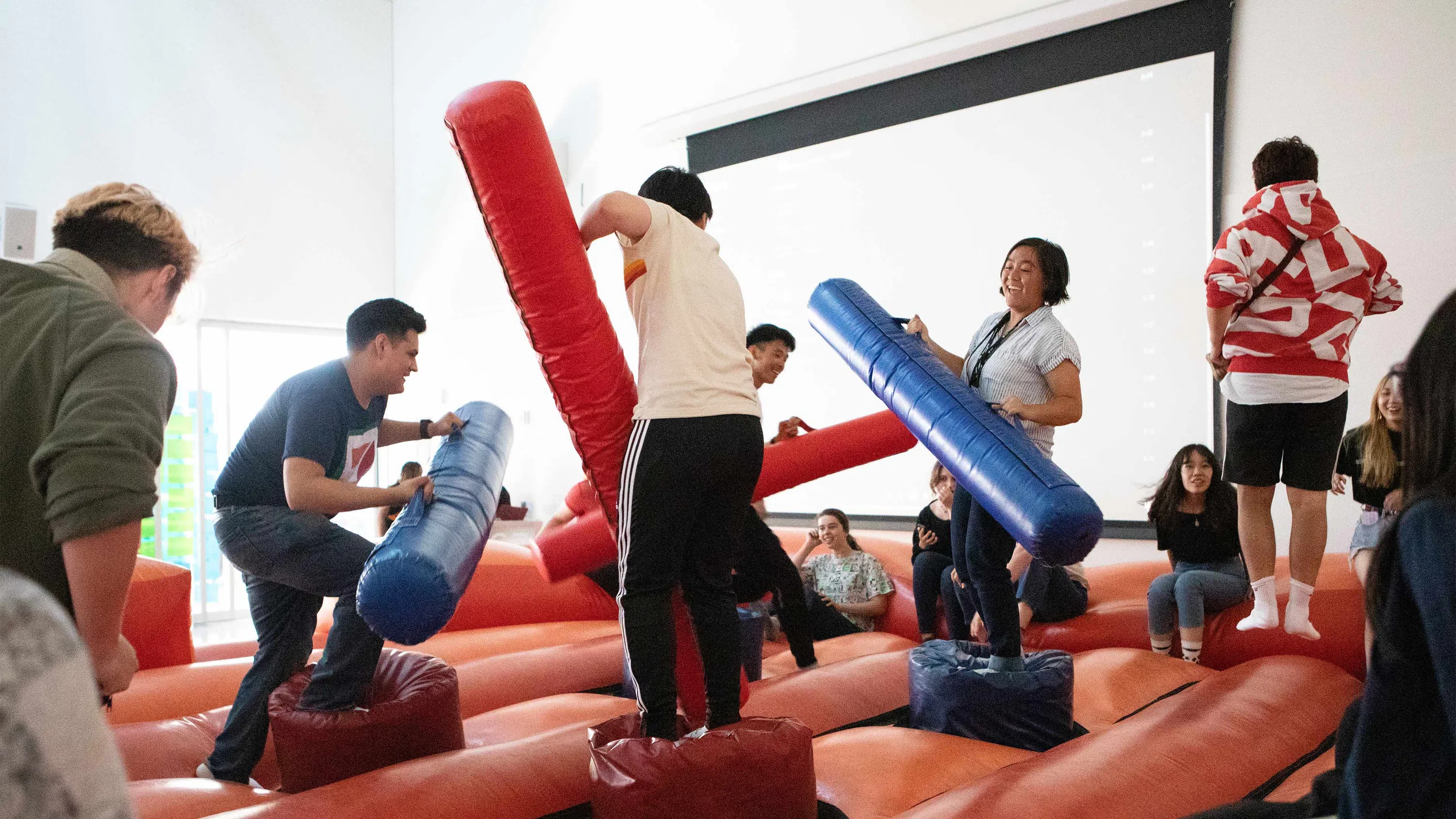 A dozen students play in an inflatable bounce house.